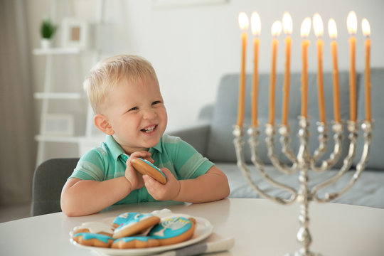 Jewish Boy Eating Festive Hanukkah Cookies At Home