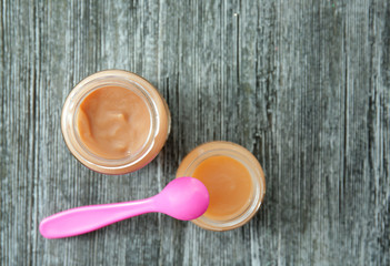 Jars with baby food on wooden table