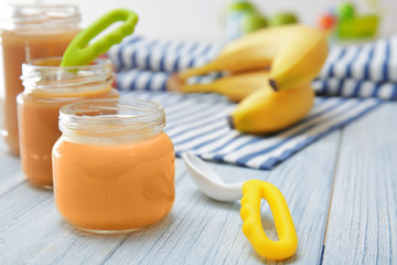 Jar with baby food on wooden table