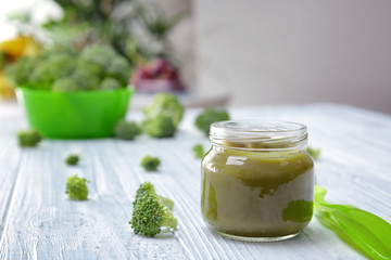 Jar with baby food on wooden table