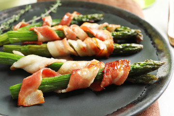 Plate with bacon wrapped asparagus, closeup
