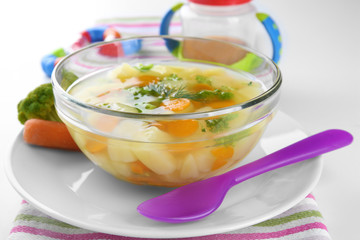 Bowl of delicious baby soup on table