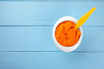 Bowl of creamy baby carrot soup on wooden table