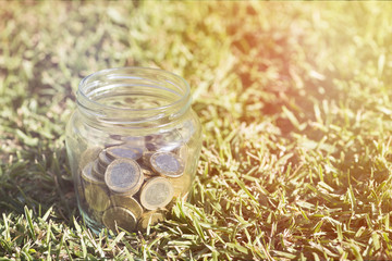 A transparent jar with many coins saved