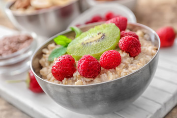Tasty oatmeal with fruits in bowl, close up