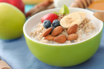 Tasty oatmeal with fruits in bowl, close up