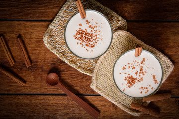 Eggnog houmemade with cinnamon and kakao for Christmas and winter holidays or wooden broun backgrounds
