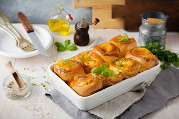 Buns with feta cheese and basil of yeast dough on a light wooden background. Selective focus. Rustic style.