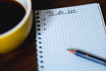 To do list in the notebook with a cup of tea