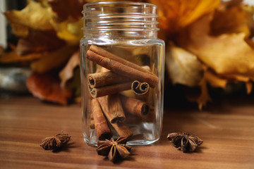 Cinnamon in a jar with leaves as a background
