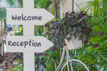 Welcome and Reception text on white label beside wildflowers in bicycle basket.