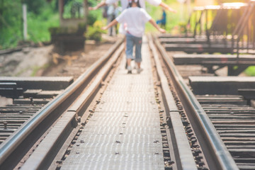 Railroad tracks on The Bridge of River Kwae is historic buildings and landmark of Kancjanaburi Province, Thailand. (Selective focus)