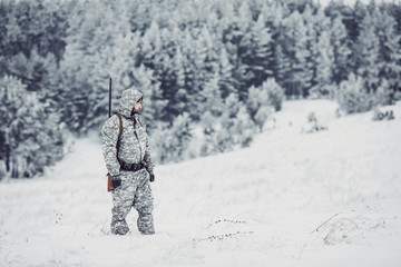 Male hunter in camouflage looking for his target or prey .Winter scene