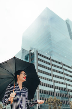 Smiling woman outdoors in the city with umbrella