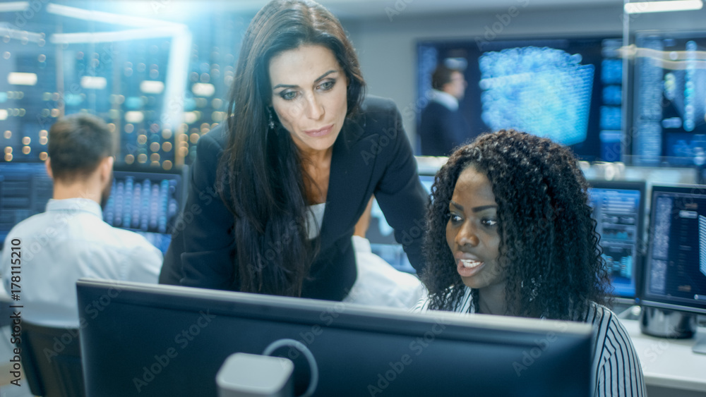 Poster Female Team Leader Consults Young Computer Engineer. They Work in a Crowded Office on a Neural Network/ Artificial Intelligence Project.