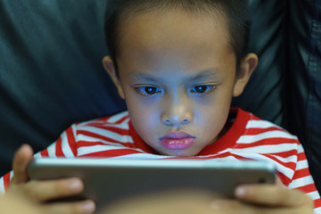 Cropped view of little boy using a digital tablet at home