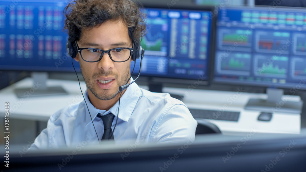Poster broker making sales with a headset with his multi-ethnic team of stock traders at the stock exchange