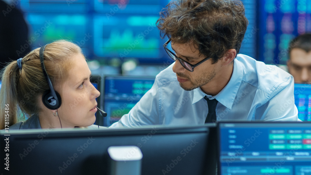 Poster experienced stock exchange trader teaches his apprentice at her workstation. multi-ethnic team at st