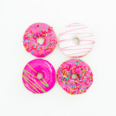 Colorful bright donuts on white background. Delicious food.  Flat lay, top view