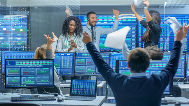 Multi-Ethnic Team of Traders Have Successful Day at the Stock Exchange Office. Dealers and Brokers Buy and Sell Stocks on the Market, they Celebrate Profitable Transaction.