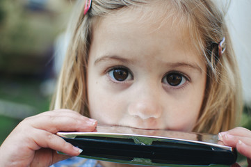 little girl playing a harmonica