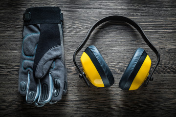 Protective glove ear muffs on wooden board
