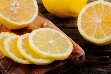 Fototapeta na wymiar Fresh ripe lemon slices on wooden background