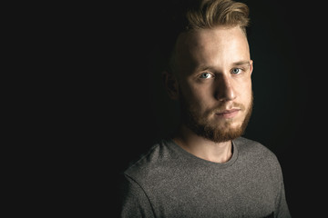 portrait of young man above black background