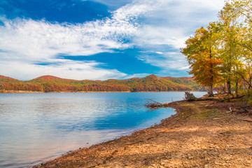 Autumn season at lake with beautiful forest at hill shore.