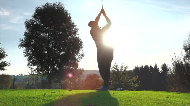 Golf Player plays golf on a beautiful summer morning. wide angle Lens flare Back lite shot 