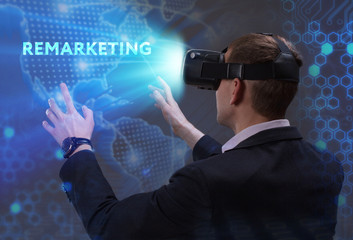 Business, Technology, Internet and network concept. Young businessman working in virtual reality glasses sees the inscription: Remarketing