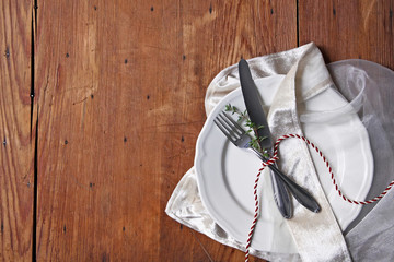 table setting with thyme branch and red and white ribbon