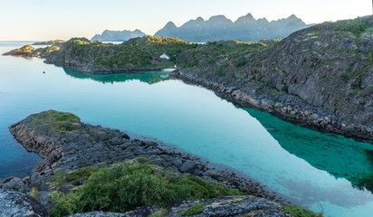Obraz premium View from theTrollskarholmen islet to rocky shore in the evening, Arstein, Lofoten, Norway,