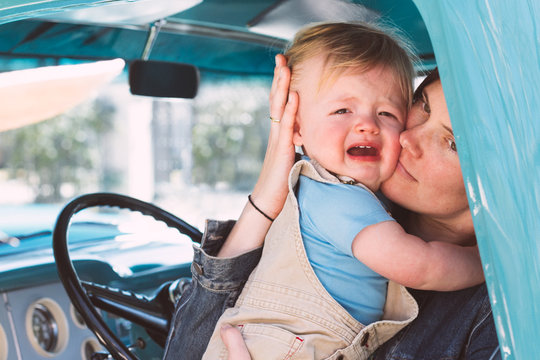 Young Mother Soothes Her Baby Son