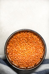 Red lentils in a clay dish with a towel