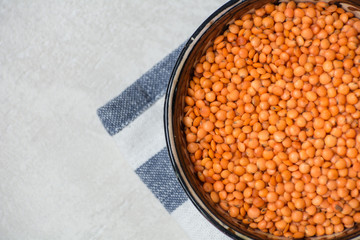 Red lentils in a clay dish with a towel