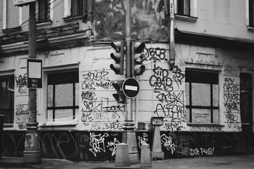Fototapeten Die Ghettostraße der Stadt malte Graffiti und Tagging. Schmutzige Zeichnungen an den Mauern der Stadt. Künstlerische oder soziale Fotografie. Schmutzige Wände in der Inschrift. Ampel-Stopp-Schild. © phormes