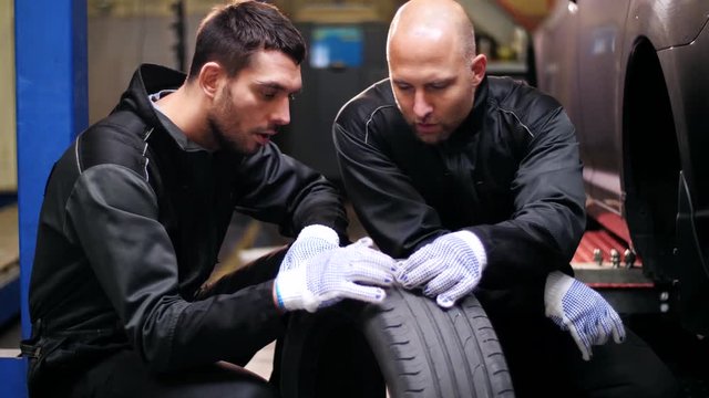 auto mechanics repairing car tire with blowout