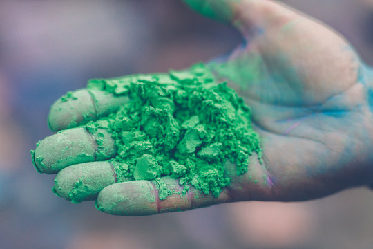 hand with green colored holi powder
