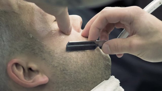 Barbershop. A hairdresser is creating a fashionable image for the young guy.
