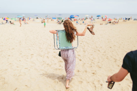 young female beach lover walks toward the ocean