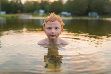Fototapeta premium Boy swimming at sunset
