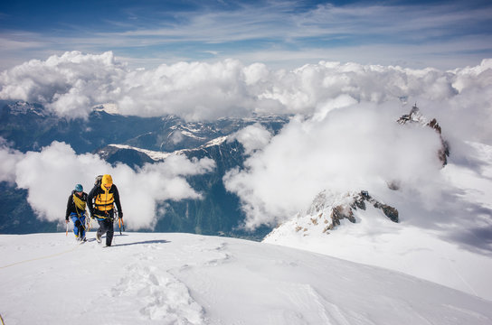 Male and female hikers walking on snow covered landscape