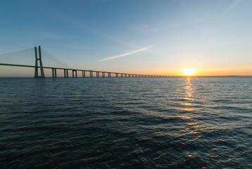 Fototapeta na wymiar sunrise over vasco da gama suspension bridge in lisbon portugal