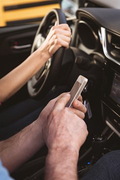 Couple using mobile phone while travelling in car