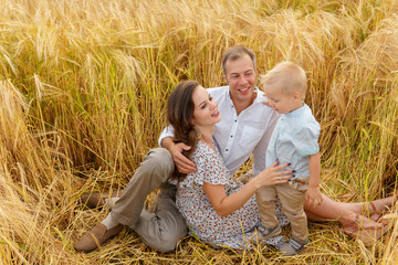 Family sitting on the grass in a wheat field