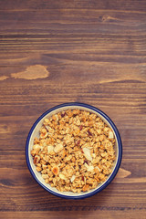 granola with nuts in the bowl on wooden background