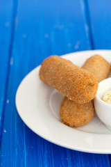 meat croquets with sauce on white plate
