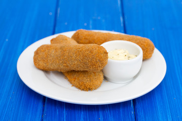 meat croquets with sauce on white plate
