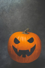 Bright Orange Pumpkin with Jack O Lantern Scary Face Painted in Black. Halloween Greeting Card Poster Party Invitation Template. Spooky Gloomy Copy Space